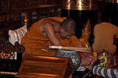 Chiang Mai - The Wat Chedi Luang, inside the viharn, Buddhist monk gives the sacred thread (sai sin).
